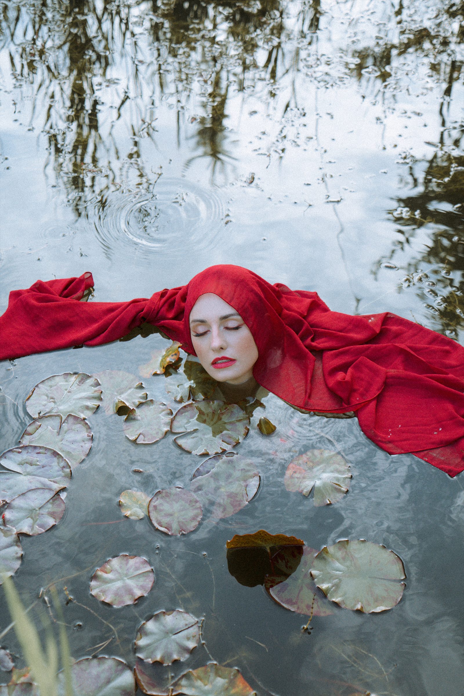 Surrealistyczny portret w czerwieni na tafli wody